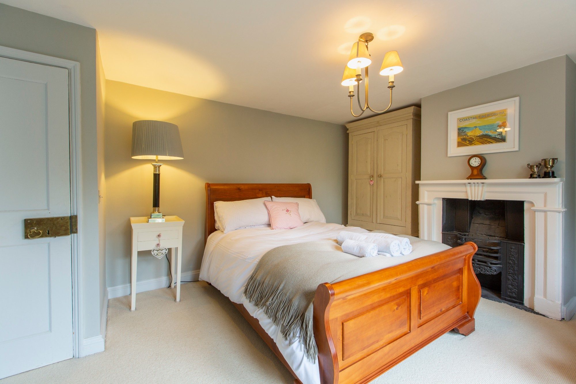 Bedroom in sage green with a pine sleigh bed and original cast-iron fireplace